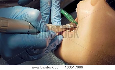 Woman at the dentist clinic office gets dental medical examination and treatment. Close up shot. Odontic and mouth health is important part of modern human life that dentistry help with.