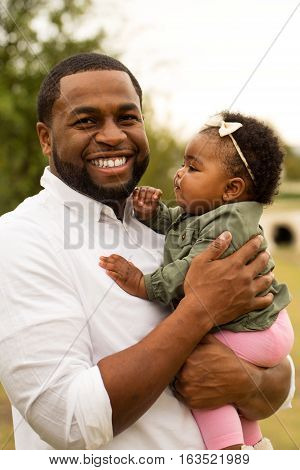 African American loving father holding his daughter.