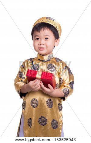 Vietnamese little boy in traditional Aodai, holding a red gift standing isolated on white background