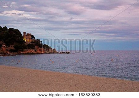 Castell d'en Plaja situated at the end of the Sa Caleta beach in Lloret de Mar in the evening, Costa Brava, Spain