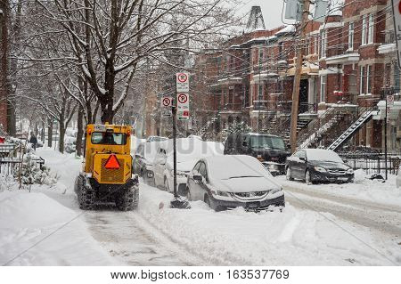 Montreal CA - 12 December 2016: A snowplow in motion in Mile End Neighbourhood during snow storm.