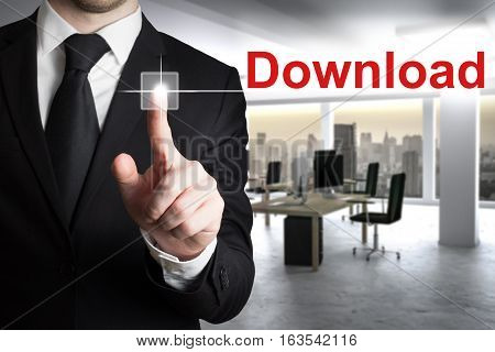 businessman in modern office pushing button download