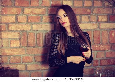 Woman Tasting Wine In Rural Cottage Interior