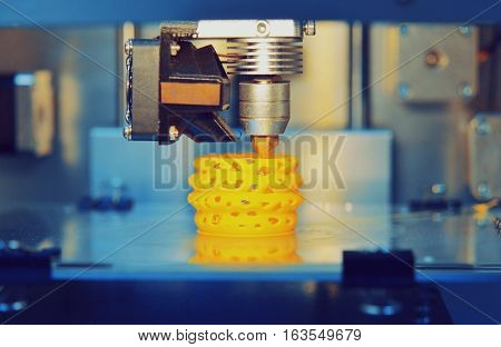 3d printer printing objects yellow form closeup. Modern technical 3D printing.