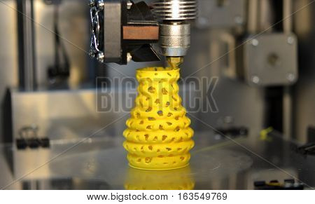 3d printer printing objects yellow form closeup. Modern technical 3D printing.