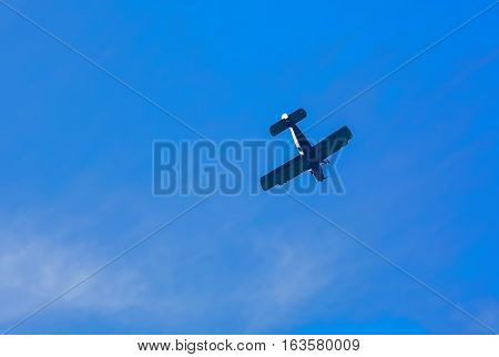 Old civil plane AN2 flying to the dark blue sky