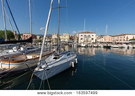 BARDOLINO ITALY - MAY 4 2016: Sailboats and fishing boats at Porto di Bardolino harbor on The Garda Lake . Italy