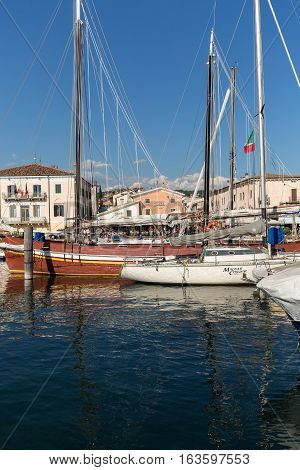 BARDOLINO ITALY - MAY 4 2016: Sailboats and fishing boats at Porto di Bardolino harbor on The Garda Lake . Italy