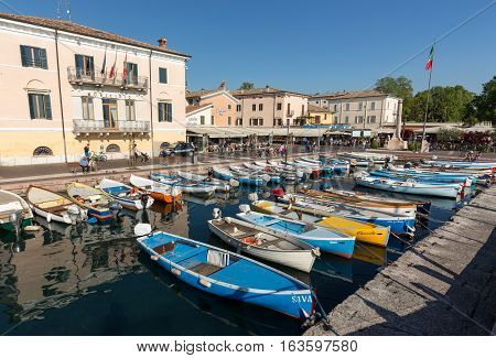 BARDOLINO ITALY - MAY 4 2016: Sailboats and fishing boats at Porto di Bardolino harbor on The Garda Lake . Italy