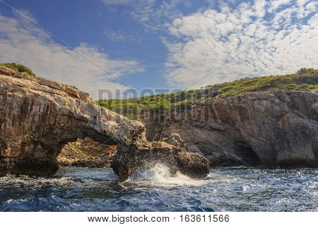 Nature landscape of Gargano National Park: coast of Tremiti Islands' archipelag,Italy (Apulia). Natural arch and the cliffs topped by Aleppo pine forest native to the Mediterranean region.