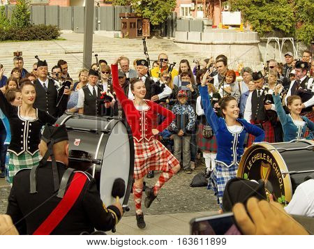MOSCOW, RUSSIA - September 4, 2016: Girls dancing during show of Celtic pipes and drums band surrounded by townspeople in the Park on the Crimean embankment. Festival of military orchestras 