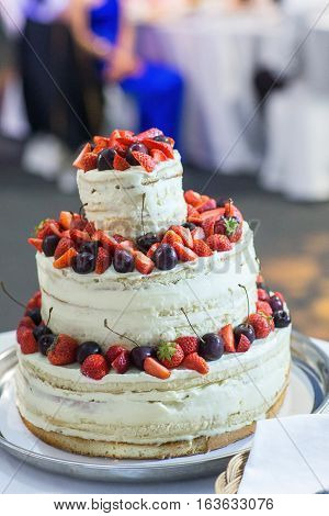 wedding cake with layers placed on a table in a restaurant in the chamber Svete variety of fruits and berries