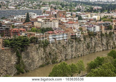 Georgia Tbilisi. View from the fortress Narikala on Avlabari district houses on a cliff leaving the water in the Kura River .