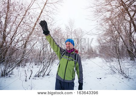 Smiling Happy Hiker Is Waving His Hand, Standing On The Trail