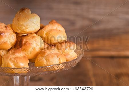 Group of sweet cream puffs on glass tray.