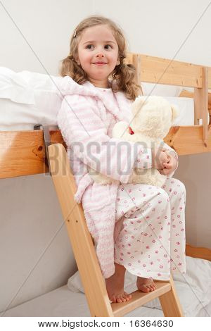 Roztomilá dívka v pyjama objímání no-name medvídek