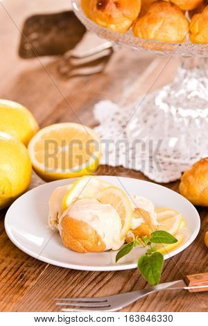 Lemon Profiteroles with custurd cream on white dish.