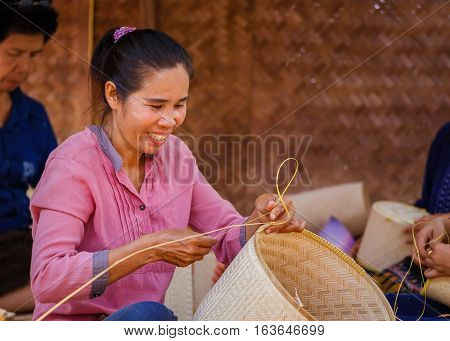 BANGKOK, THAILAND - JANUARY 14 2016: Unidentified female makes Thai bamboo basket  in the celebration of Thai Traditional Culture Festival at Lumpini Park