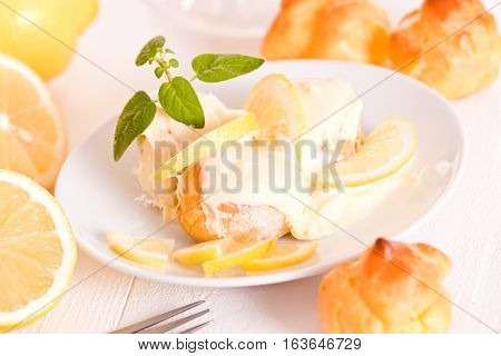 Lemon Profiteroles with custurd cream on white dish.