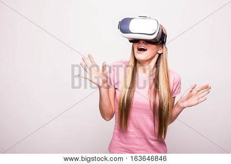 Happy woman wearing virtual reality goggles on white