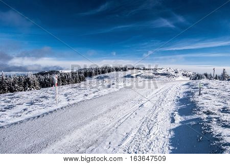 winter hiking trail with snow and blue sky with few clouds in Fischbacher Alpen mountains in Styria