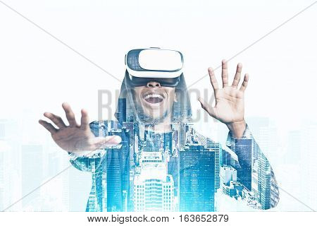 Portrait of an African American guy in a hoodie and vr glasses playing an exciting game. Concept of the future is here. Toned image. Mock up. Double exposure