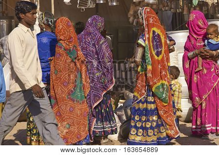 NAGAUR, RAJASTHAN, INDIA - FEBRUARY 16, 2008: Group of women in brightly coloured clothing shopping amongst the many temporary stalls at the annual livestock fair in Nagaur, India.