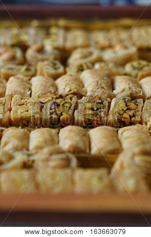 Macro detail of typical Arabian sweets(asabe, balluriah, eschkajoo, turkiya) set in rows of different kinds of eastern pastry