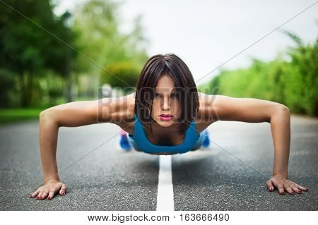 woman doing exercises on the asphalt road