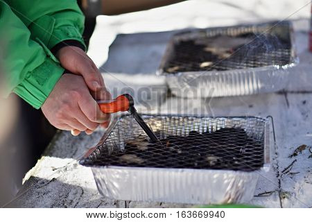 Aluminum disposable (throwaway) outdoor grill used in winter as a temperature contrast between hot grill grid and freezing snow during the December cookout