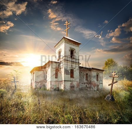 Abandoned church near the cemetery in a field