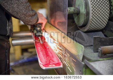Maintenance of skis. Grinding and sparks. Ski service