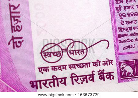 Closeup of new Indian Currency note new INR 2000 banknote with swatch bharat programme making clean India and eye glasses of Mahatma Gandhi