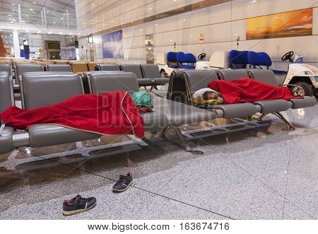 Mother and daughter sleeping on the airpot departure gates bench. Tireing travel concept.