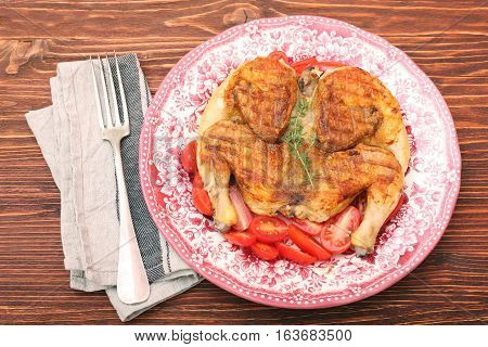 Grilled chicken Tabaka on wooden table. Georgian cuisine