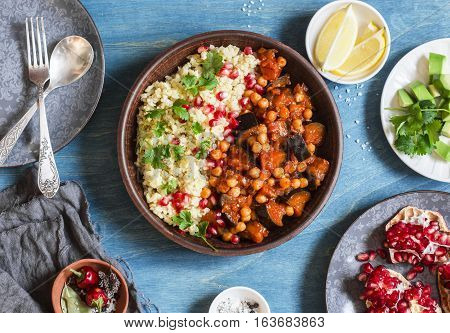 Vegetarian lunch table - eggplant and chickpea stew bulgur pomegranate and avocado. Top view flat lay