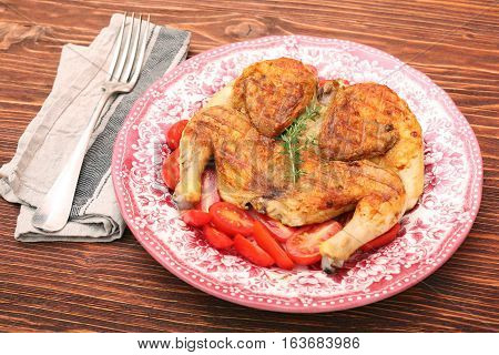 Grilled chicken Tabaka on wooden table. Georgian cuisine