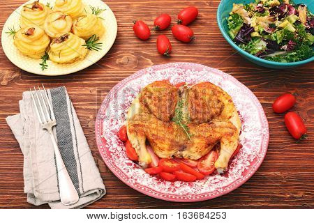 Grilled chicken Tabaka on wooden table. Georgian cuisine