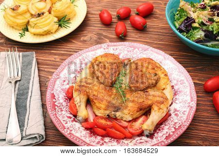 Grilled chicken Tabaka on wooden table. Georgian cuisine