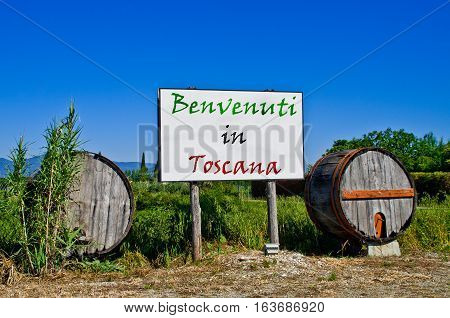 Billboard road surrounded by two wine barrels to welcome the tourists who come to visit Tuscany