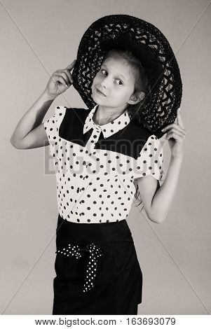 Beautiful young girl in black hat on his head. Black and white image