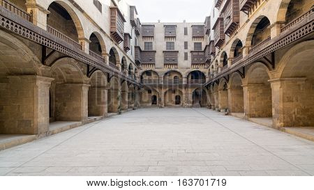 Facade of caravansary (Wikala) of Bazaraa with vaulted arcades and windows covered by interleaved wooden grids (mashrabiyya) suited in Tombakshia street Al Gamalia district Medieval Cairo Egypt