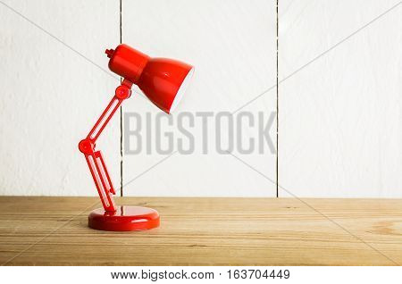 Red lamp on wood table over white background