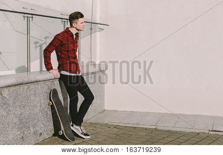 young man and sakteboard on the city street