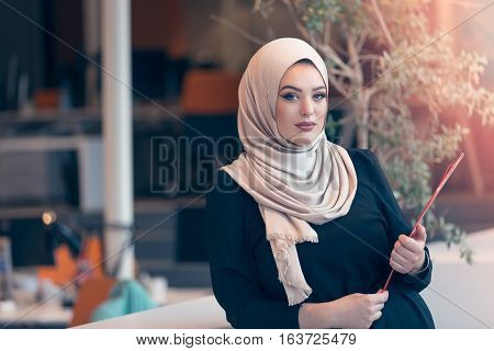 Arabian business woman holding a folder and talking on the phone isolated on white
