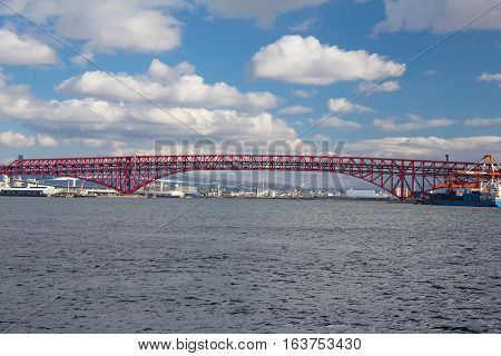 Minato Bridge in Osaka, Japan over seaport skyline and blue sky