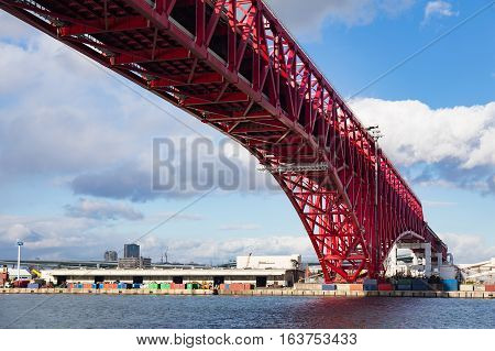 Minato Bridge In Osaka, Japan Over Seaport Skyline And Blue Sky Background
