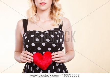 Valentine day gift proof of love romantic present concept. Woman in retro polka dot dress holding small furry red heart