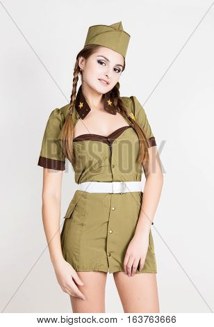 sexy fashionable woman in military uniform and forage-cap, posing.