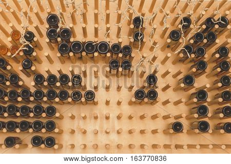 The bottles on the shelves of the wine cellar. Front view